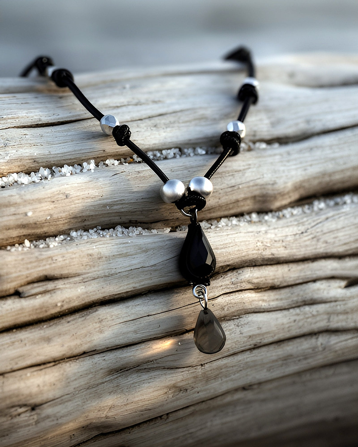 NK-04 black teardrop y-necklace, round beads — on driftwood