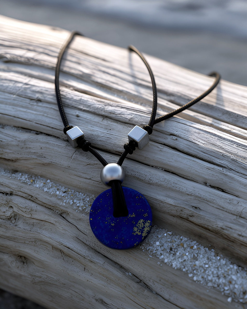 NK-09 lapis disc pendant — on driftwood