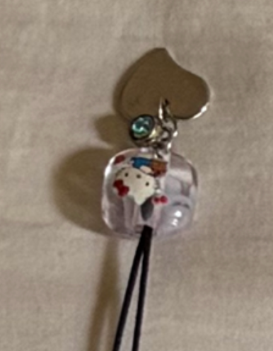 Light character cube bead with heart and green crystal, real necklace detail